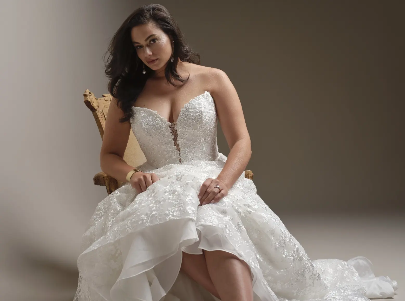 Model In A Studio Sitting Wearing Lace A Line Wedding Dress Called Memphis By Maggie Sottero