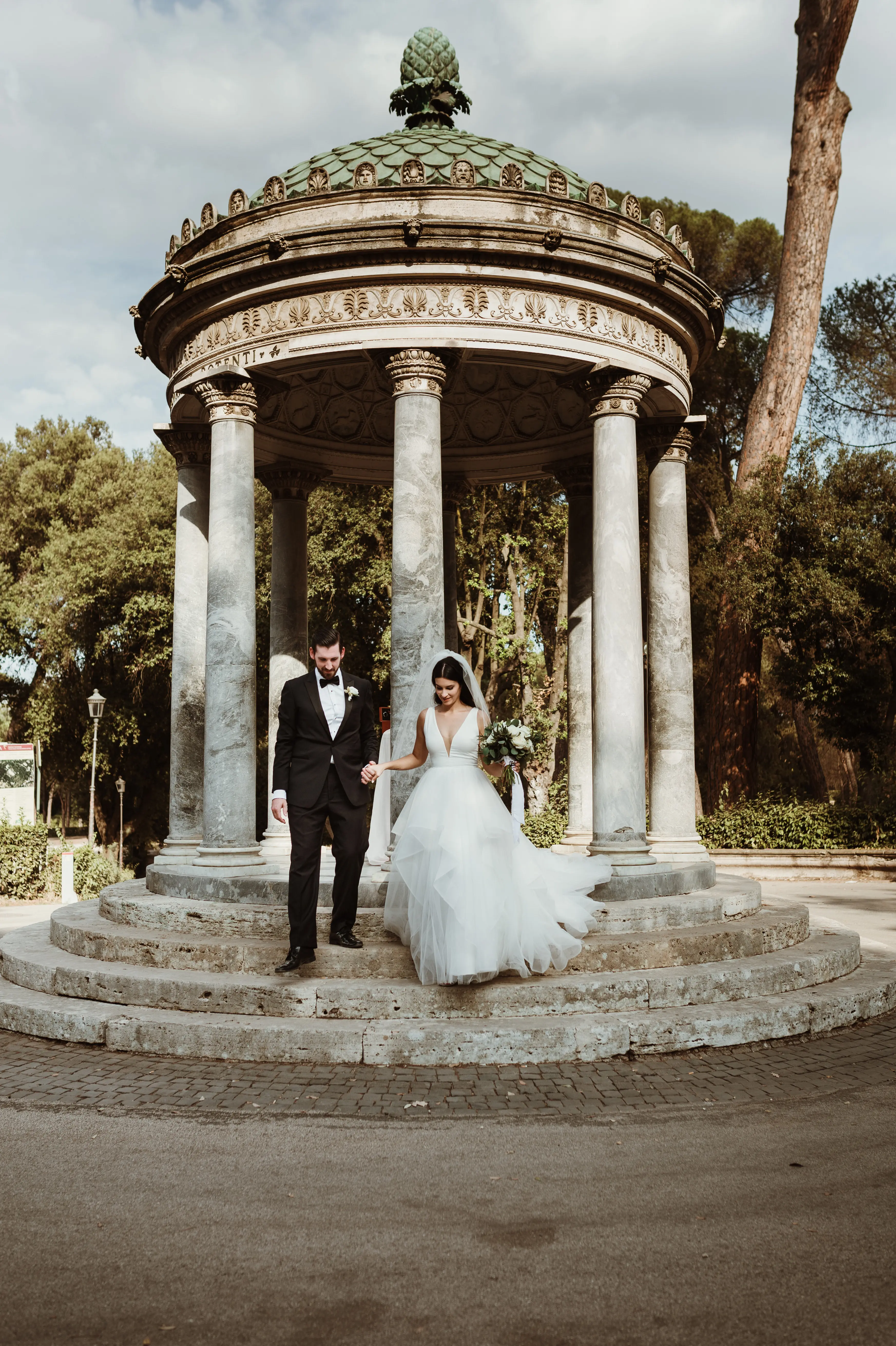 Bride with groom wearing glamorous ballgown wedding dress with deep V-neck.
