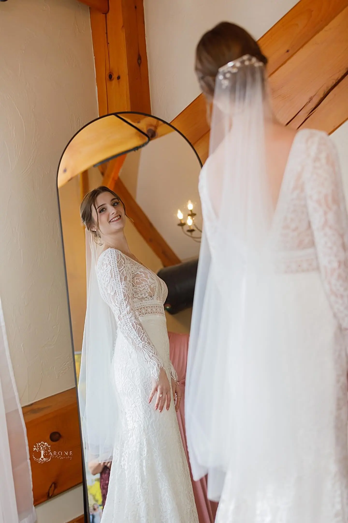 Bride Wearing Boho Sleeved Wedding Dress Called Drita By Maggie Sottero Looking In A Mirror