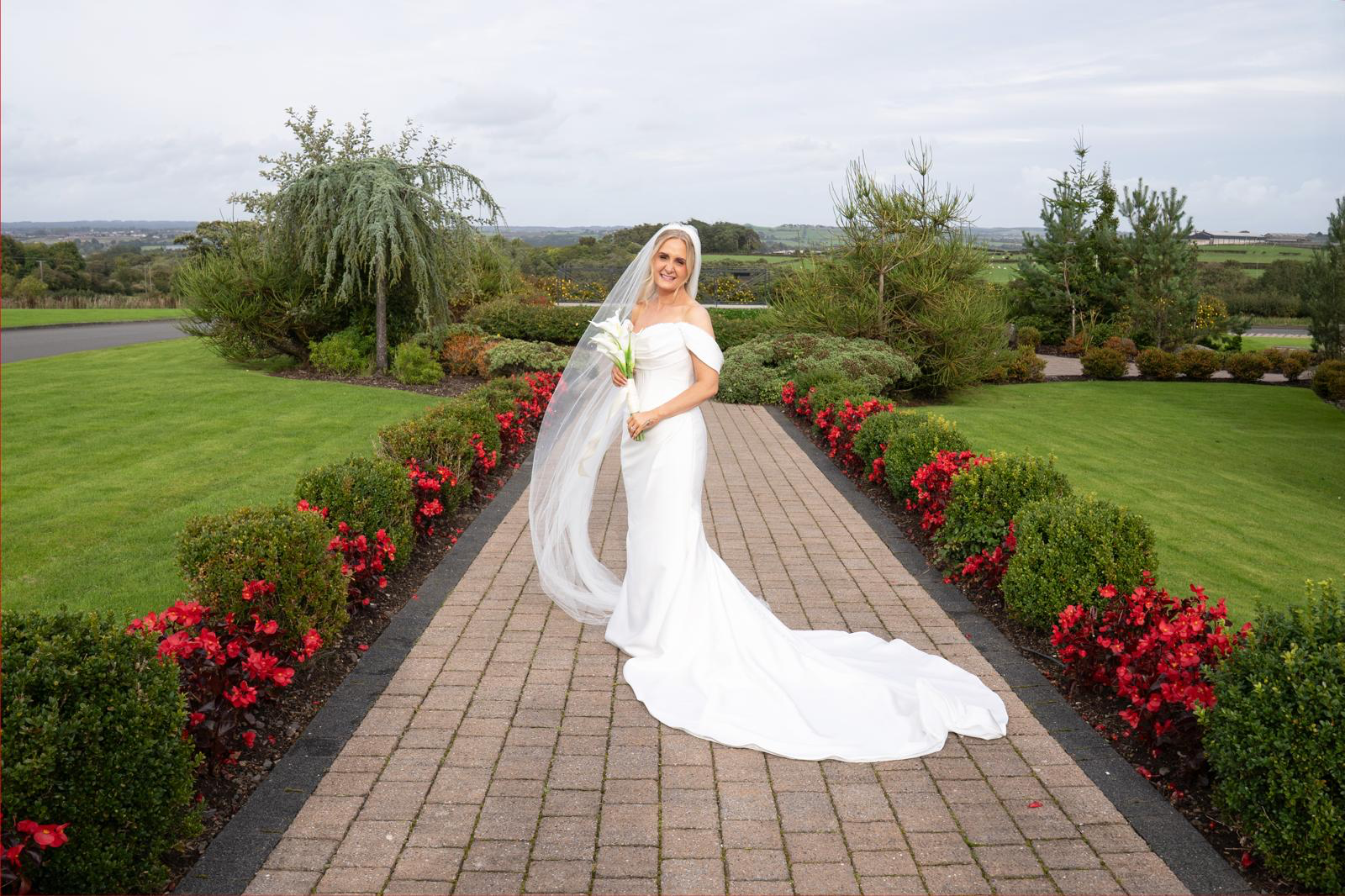 Bride Wearing Simple Off-the-shoulder Wedding Gown Called Melissa By Maggie Sottero In A Botanical Garden